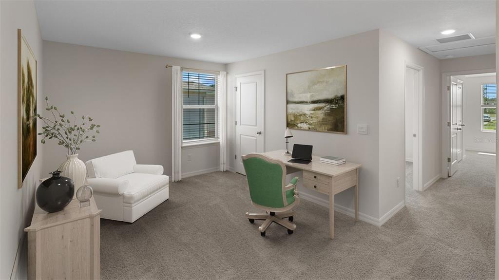 A home office with gray carpet, a white armchair, a wooden desk, and a green chair — 16534 BARBOURS CREEK WAY, WINTER GARDEN, FL