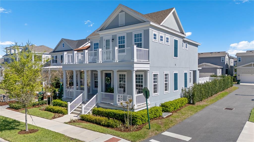 A two-story gray house with a wrap-around porch and a second-floor balcony — 7484 ESTUARY LAKE LOOP, CELEBRATION, FL