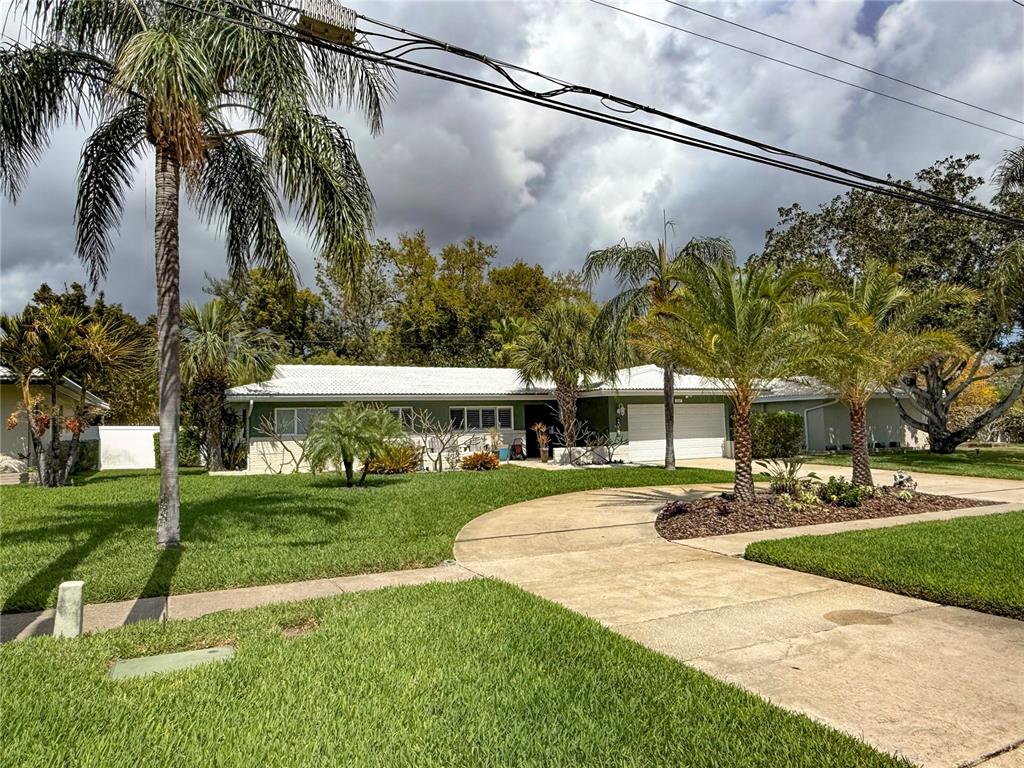 A single-story house with a white roof, green siding, and a curved concrete driveway — 2058 NURSERY ROAD, CLEARWATER, FL