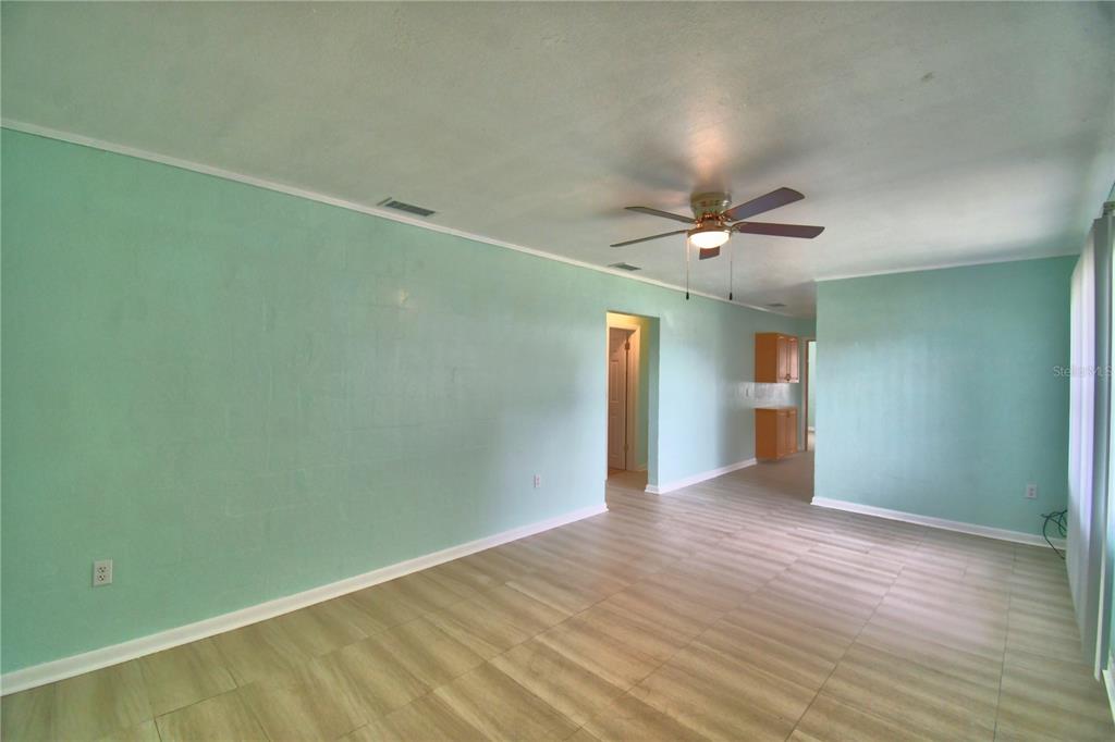 A living room with light green walls, wood-look tile flooring, and a ceiling fan — 30 MONK ROAD, FROSTPROOF, FL