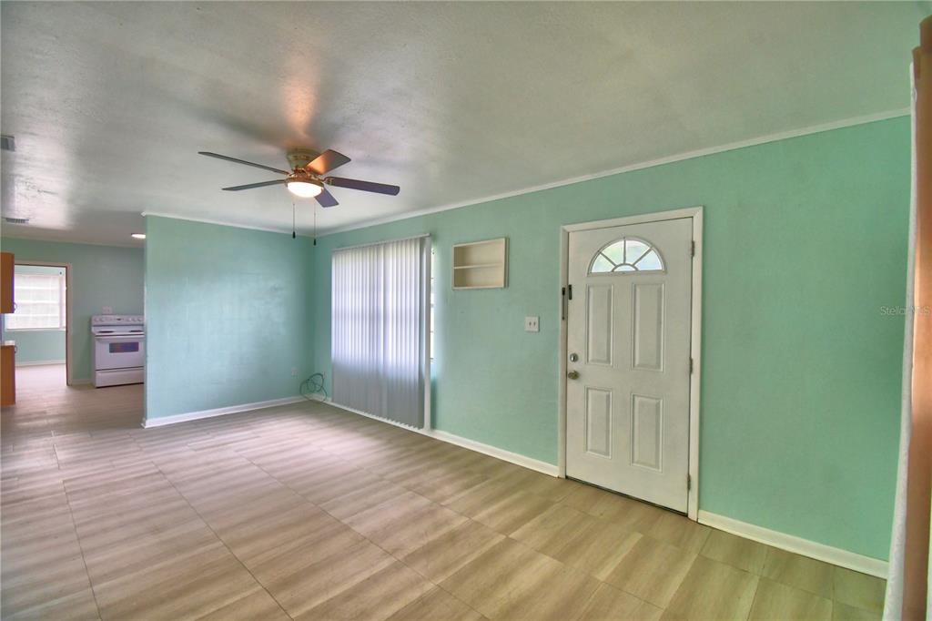 A living room with light green walls, wood-look tile flooring, and a ceiling fan — 30 MONK ROAD, FROSTPROOF, FL