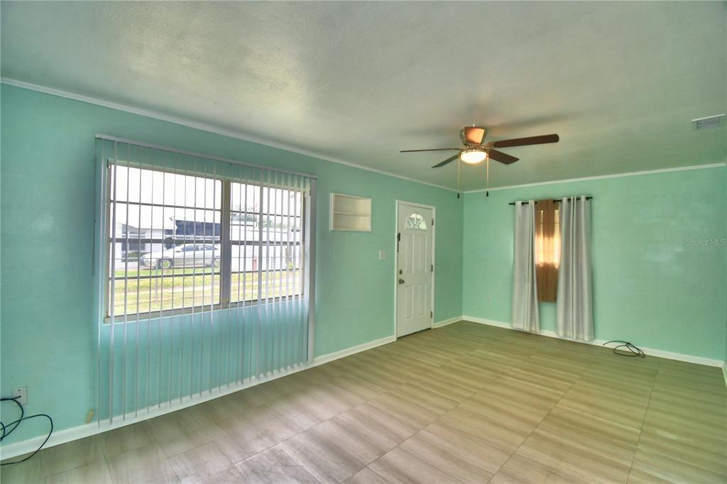 A living room with light green walls, wood-look tile flooring, and a ceiling fan — 30 MONK ROAD, FROSTPROOF, FL