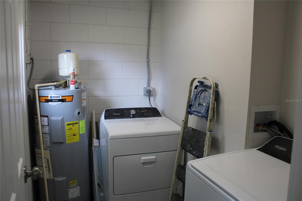 A utility room contains a water heater, a clothes dryer, and a washing machine — 9049 ORCHID DRIVE, SEMINOLE, FL