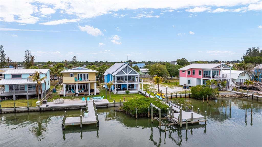 An aerial view shows several colorful waterfront houses with private docks along a canal — 18 VIP ISLAND B, GRANT, FL