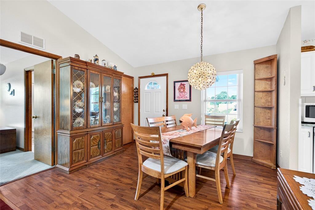 A dining room features a wooden table, chairs, a hutch, and a globe pendant light — 64 BAHIA TRACE CIRCLE, OCALA, FL