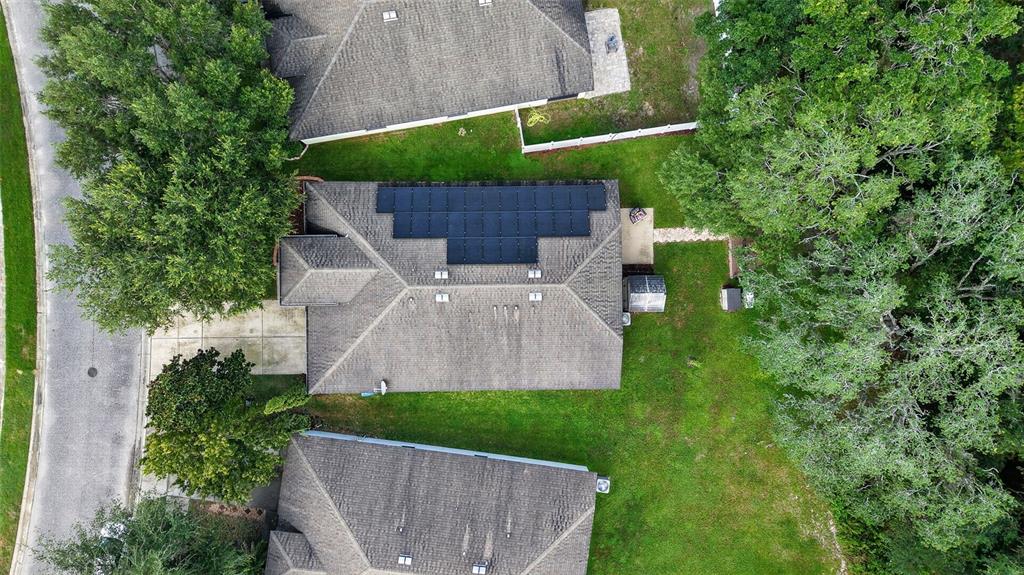 An aerial view shows a house with a solar panel array on its roof — 1234 HILL FLOWER DRIVE, BROOKSVILLE, FL