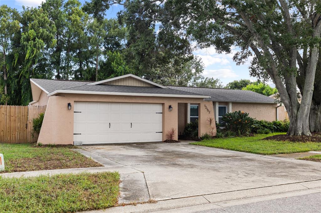 A single-story tan house with a two-car garage and large trees in the front yard — 12152 BONNIE TERRACE, SEMINOLE, FL