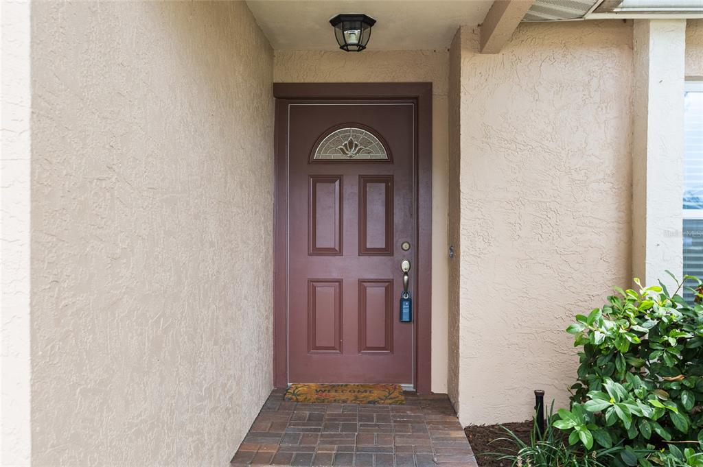 An entryway features tile flooring, a white front door, and a view into a living area — 12152 BONNIE TERRACE, SEMINOLE, FL