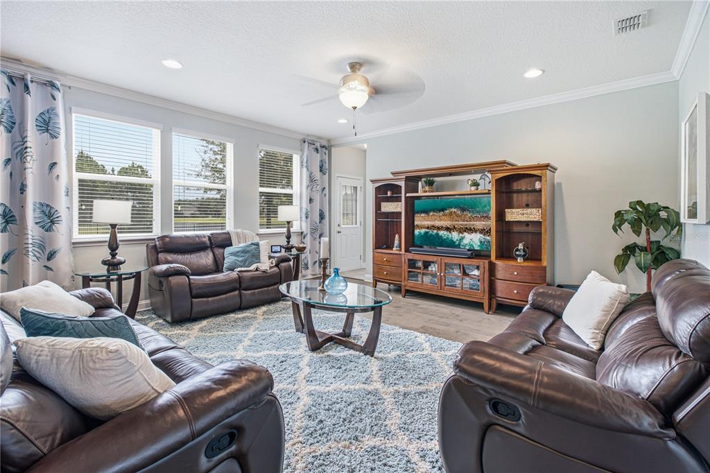 A living room features two brown leather sofas, a glass coffee table, and a wooden entertainment center — 52 CROSSWOOD COURT, ST AUGUSTINE, FL