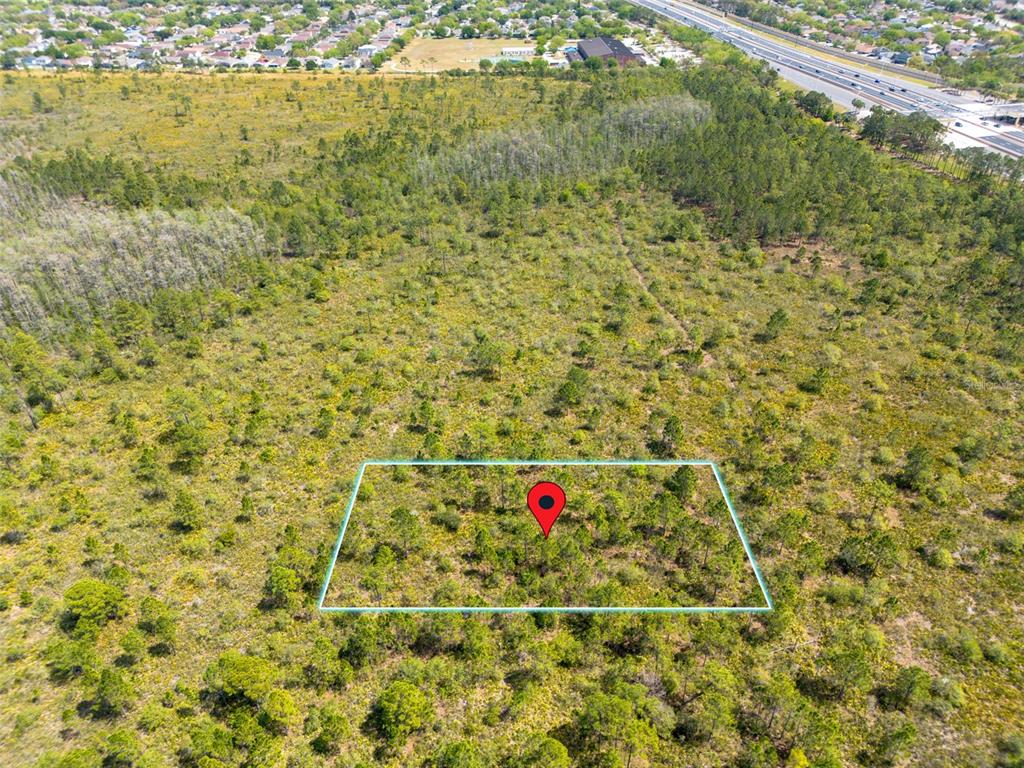 An aerial view shows a rectangular plot of land marked with a red location pin — INTERNATIONAL DRIVE, ORLANDO, FL