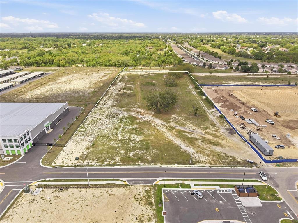 An aerial view shows a rectangular vacant lot bordered by a road and construction sites — QUALITY DRIVE, SPRING HILL, FL