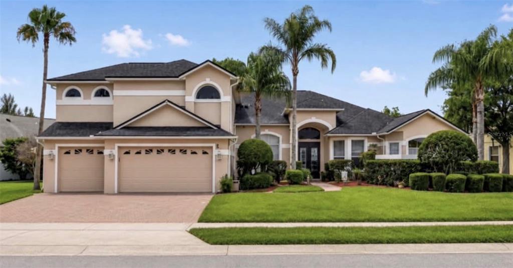 A single-story house with a brick walkway, palm trees, and manicured landscaping — 4552 LAKE CALABAY DRIVE, ORLANDO, FL
