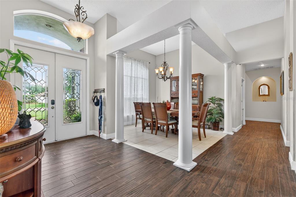 An entryway features wood-look tile flooring, a central column, a console table, and a mirror — 4552 LAKE CALABAY DRIVE, ORLANDO, FL