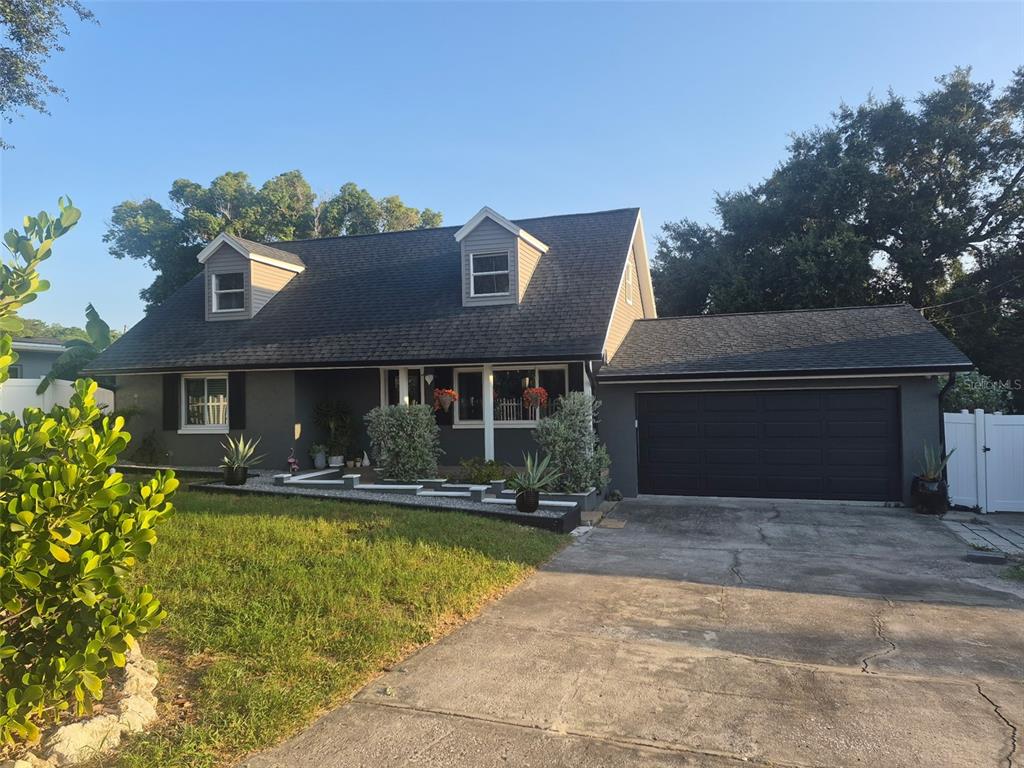 A gray two-story house with a dark roof, two dormers, and an attached garage — 1504 BIG BASS DRIVE, TARPON SPRINGS, FL