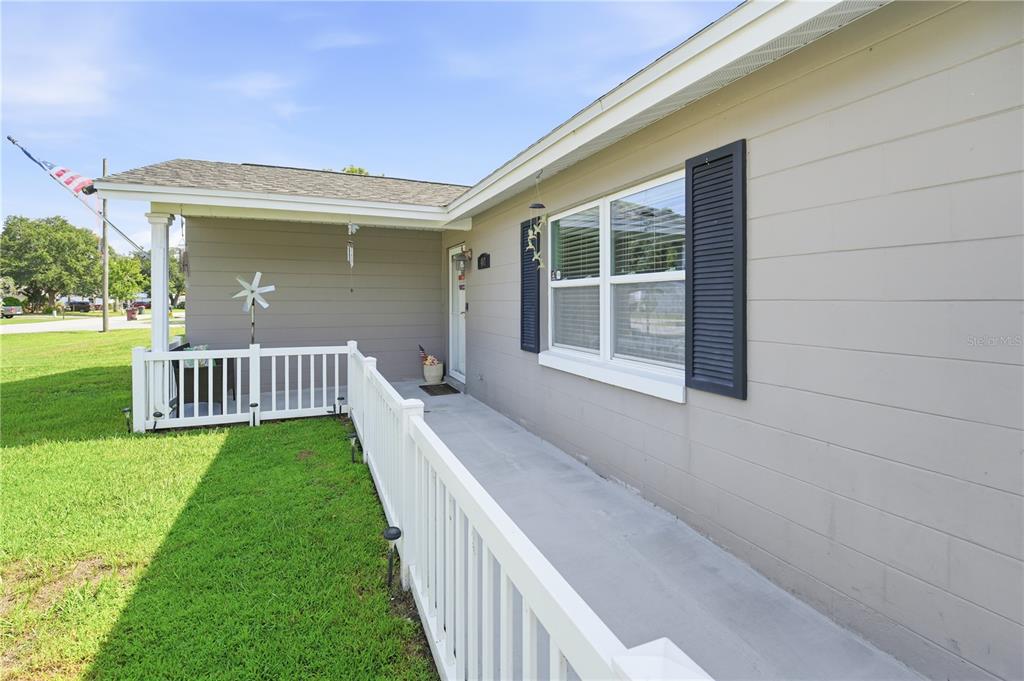 A concrete ramp with a white railing leads to the front entrance of a house — 407 TENNESSEE AVENUE, ST CLOUD, FL