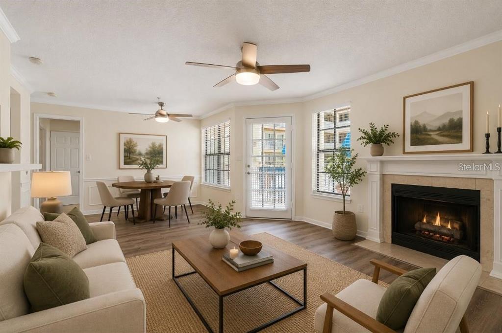 A living room with a fireplace, dining area, ceiling fans, and light-colored wood-look flooring — 1000 W HORATIO STREET UNIT 114, TAMPA, FL
