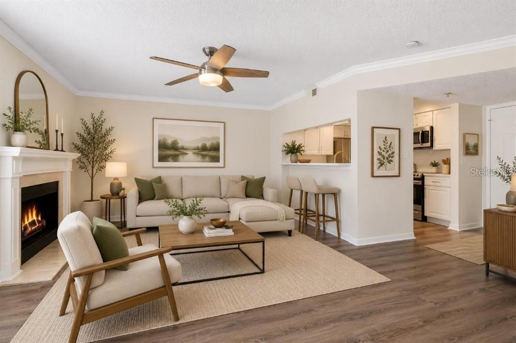 A living room with a fireplace, sectional sofa, wooden coffee table, and an open kitchen — 1000 W HORATIO STREET UNIT 114, TAMPA, FL