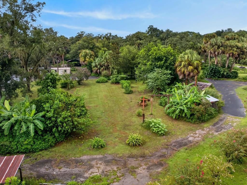 An aerial view shows a grassy yard with trees, shrubs, and a paved driveway — 11094 CR 683D, WEBSTER, FL