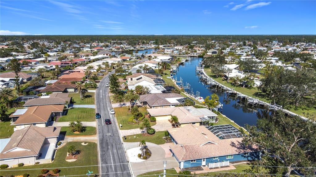 A single-story house with a tan stucco exterior, a tiled roof, and a paved driveway — 4 WINDSOR DRIVE, ENGLEWOOD, FL