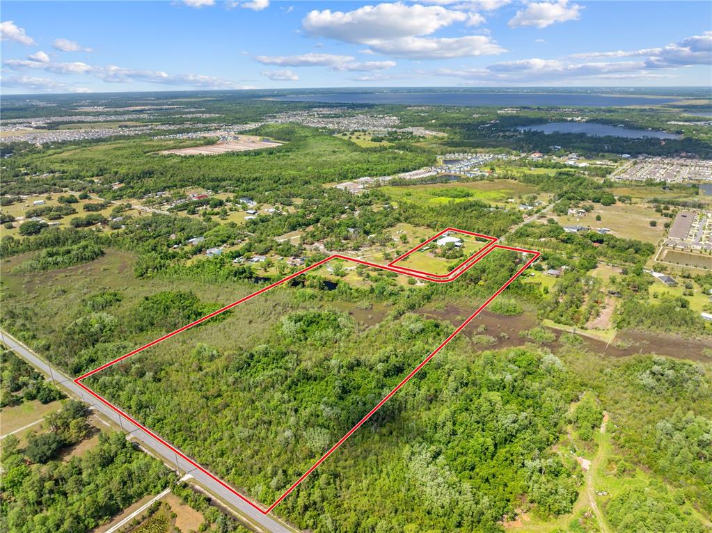 An aerial view shows a large, wooded plot of land outlined in red — 5900 LEON TYSON ROAD, ST CLOUD, FL