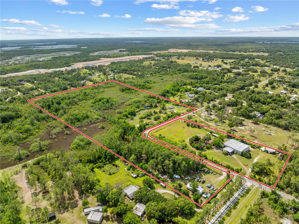 An aerial view shows a large, irregularly shaped property outlined in red with several buildings — 5900 LEON TYSON ROAD, ST CLOUD, FL
