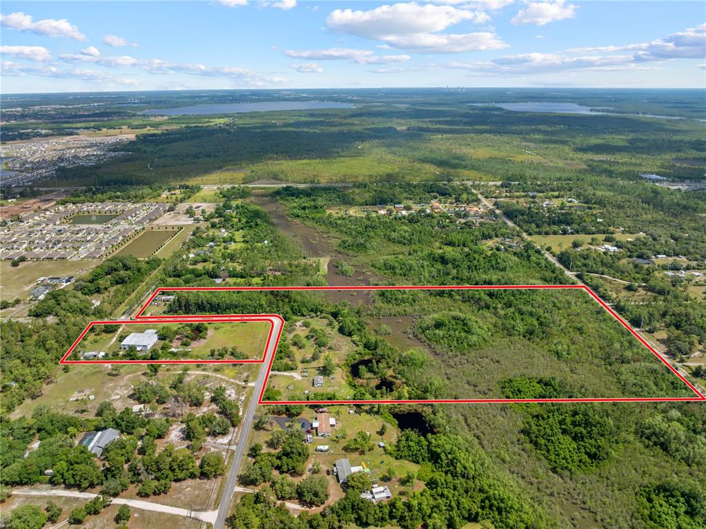 An aerial view shows a large, wooded plot of land outlined in red near residential areas — 5900 LEON TYSON ROAD, ST CLOUD, FL