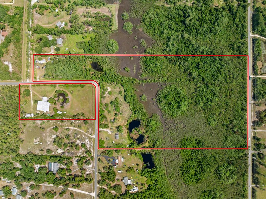 An aerial view shows a large plot of land outlined in red with wooded areas — 5900 LEON TYSON ROAD, ST CLOUD, FL