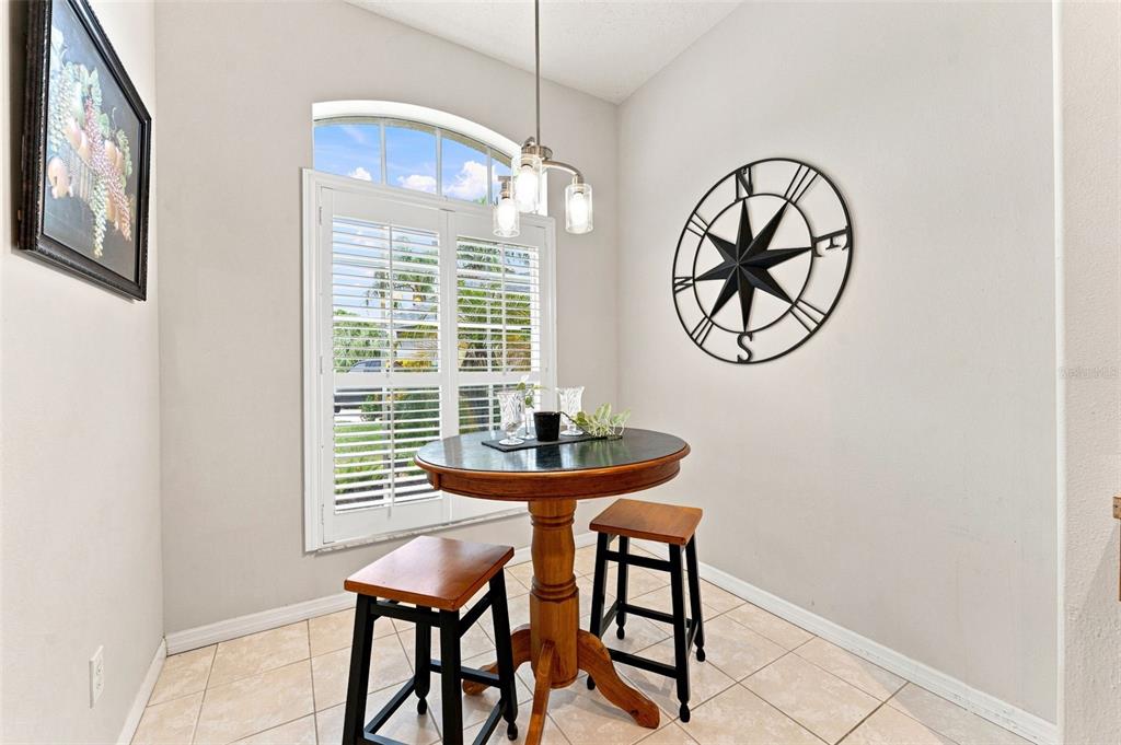 A beige house exterior features a white front door with a glass storm door — 491 BRILAND STREET, TARPON SPRINGS, FL