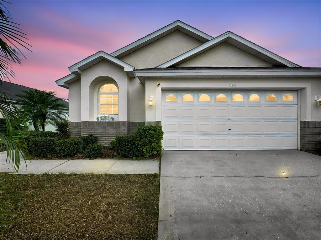A single-story suburban house features a two-car garage, a arched window, and a concrete driveway — 2615 SUMMER CREEK DRIVE, KISSIMMEE, FL