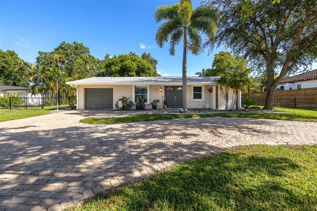 A single-story house with a paved driveway, a palm tree, and a gray garage door — 1223 BILTMORE DRIVE, FORT MYERS, FL