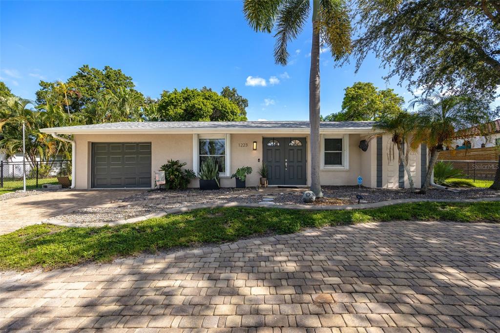 A single-story house with a beige exterior, a gray garage door, and a paved driveway — 1223 BILTMORE DRIVE, FORT MYERS, FL