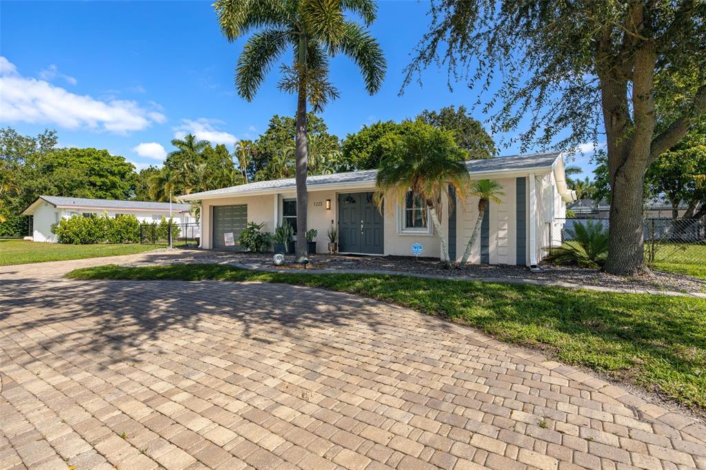 A single-story house with a paved driveway, palm trees, and a dark gray front door — 1223 BILTMORE DRIVE, FORT MYERS, FL