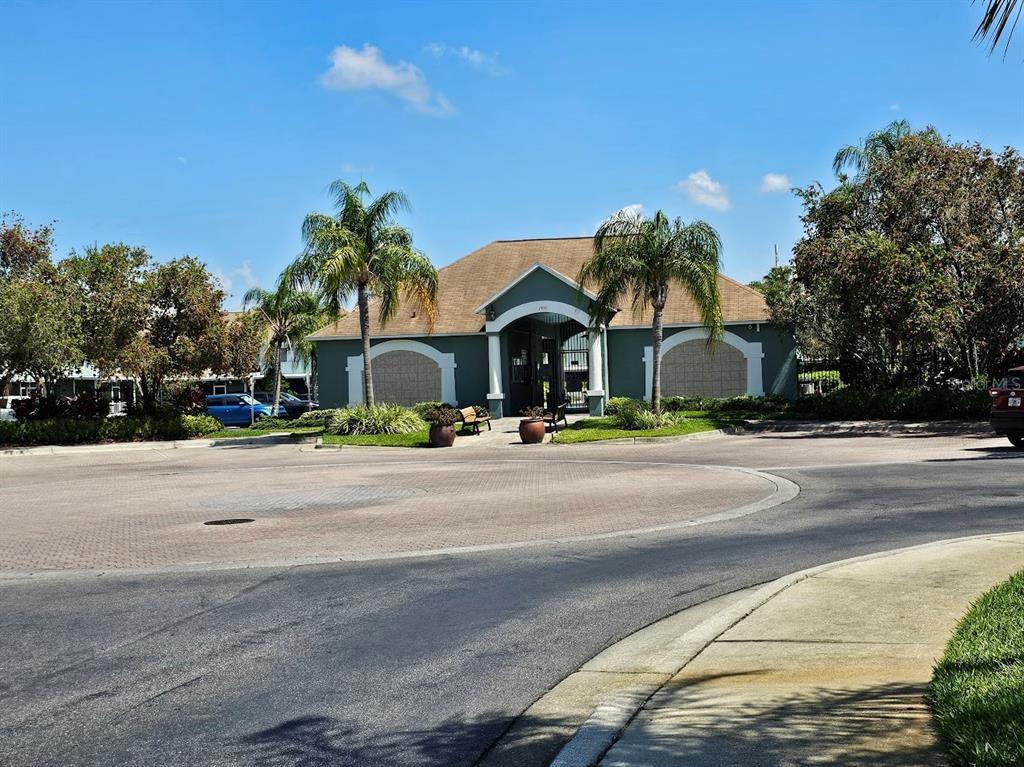 A single-story community clubhouse building with a tan roof and two palm trees in front — 2053 FLUORSHIRE DRIVE, BRANDON, FL