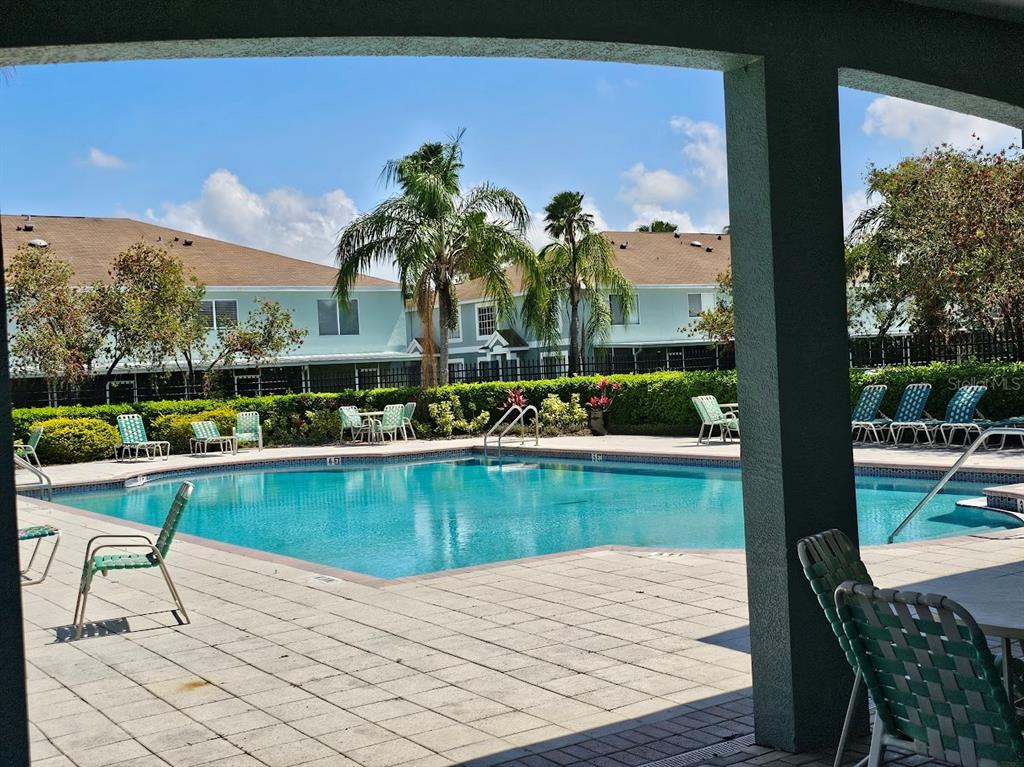 A swimming pool with lounge chairs on a patio in front of apartment buildings — 2053 FLUORSHIRE DRIVE, BRANDON, FL