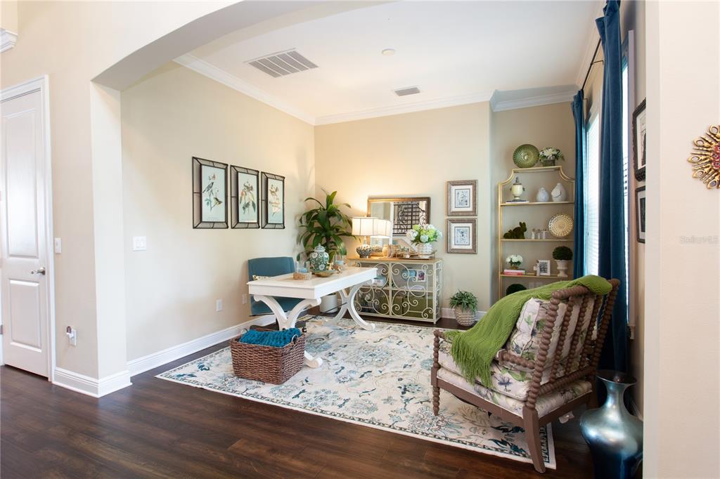 A home office features a white desk, patterned area rug, and a floral armchair — 3917 W SAN LUIS STREET, TAMPA, FL
