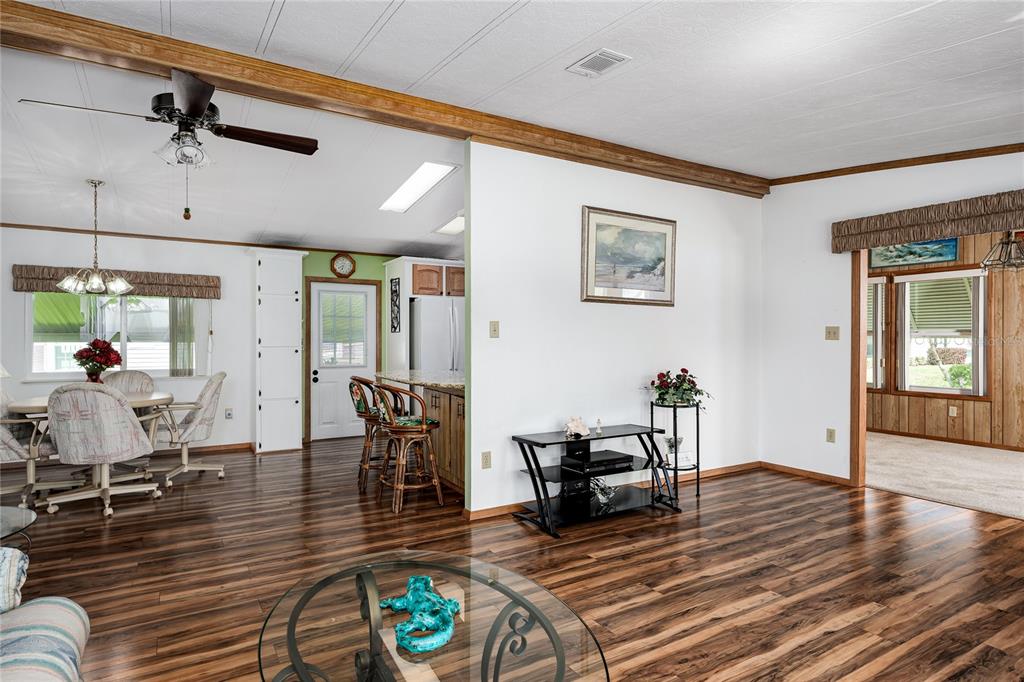A living room and dining area feature wood-look flooring, a ceiling fan, and kitchen access — 4215 14TH STREET E, ELLENTON, FL