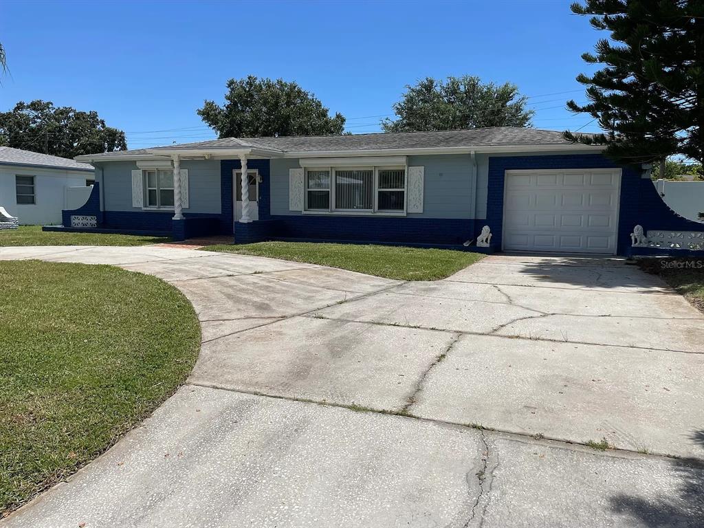 A single-story house with a blue and light gray exterior features a concrete driveway — 5003 58TH WAY N, KENNETH CITY, FL