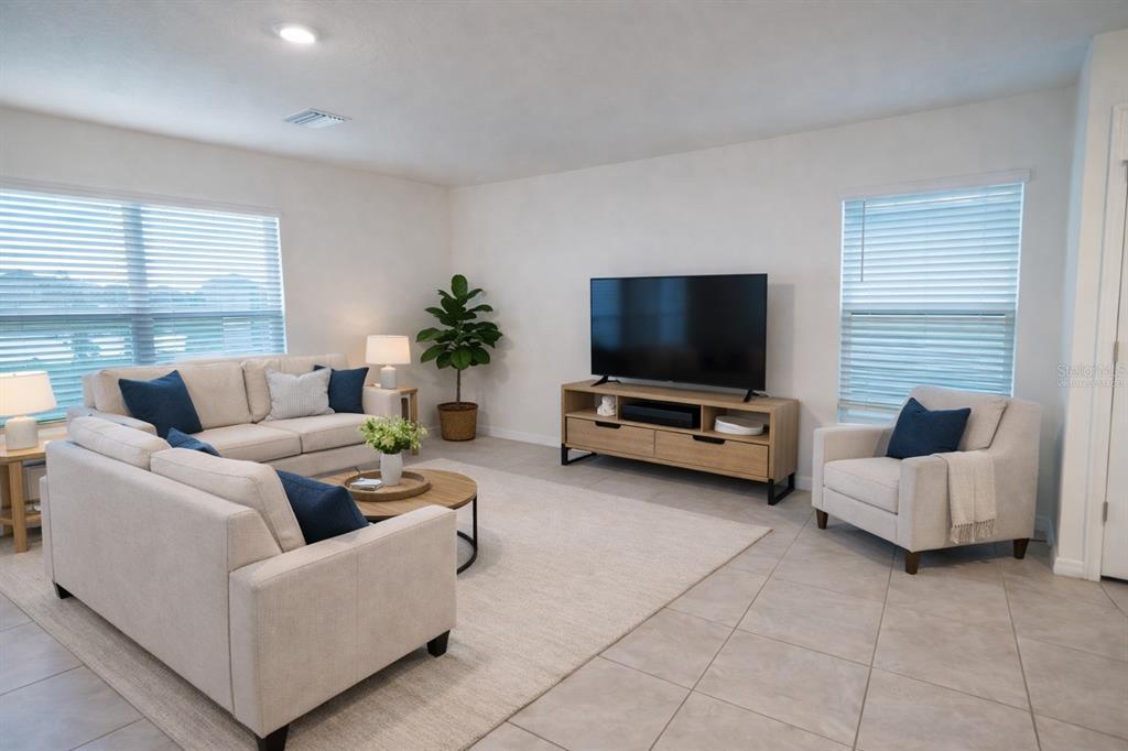 A living room features light-colored furniture, a television on a wooden console, and tile flooring — 16546 MOSAIC OAR DRIVE, WIMAUMA, FL