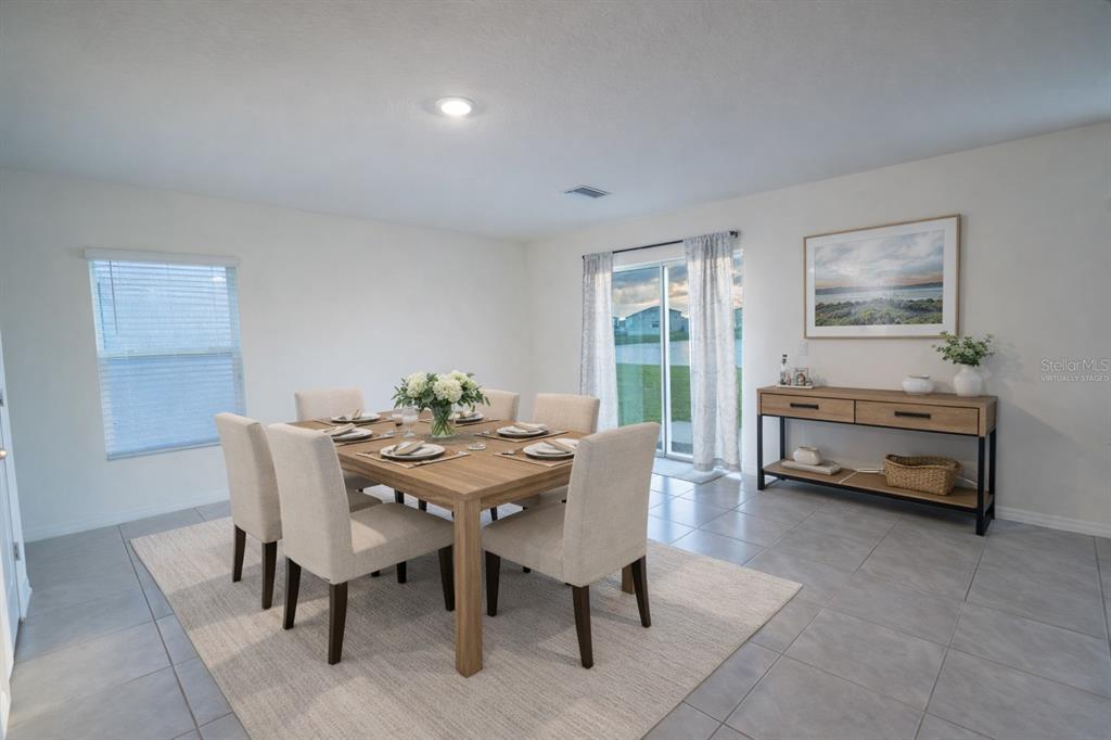 A dining room features a wooden table with six chairs, a console table, and tile flooring — 16546 MOSAIC OAR DRIVE, WIMAUMA, FL