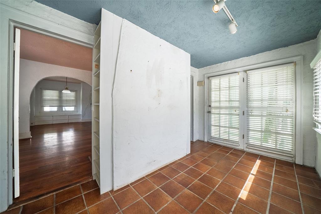 A room with terracotta tile flooring, a blue ceiling, and a white partition wall — 813 GREENWOOD STREET, ORLANDO, FL