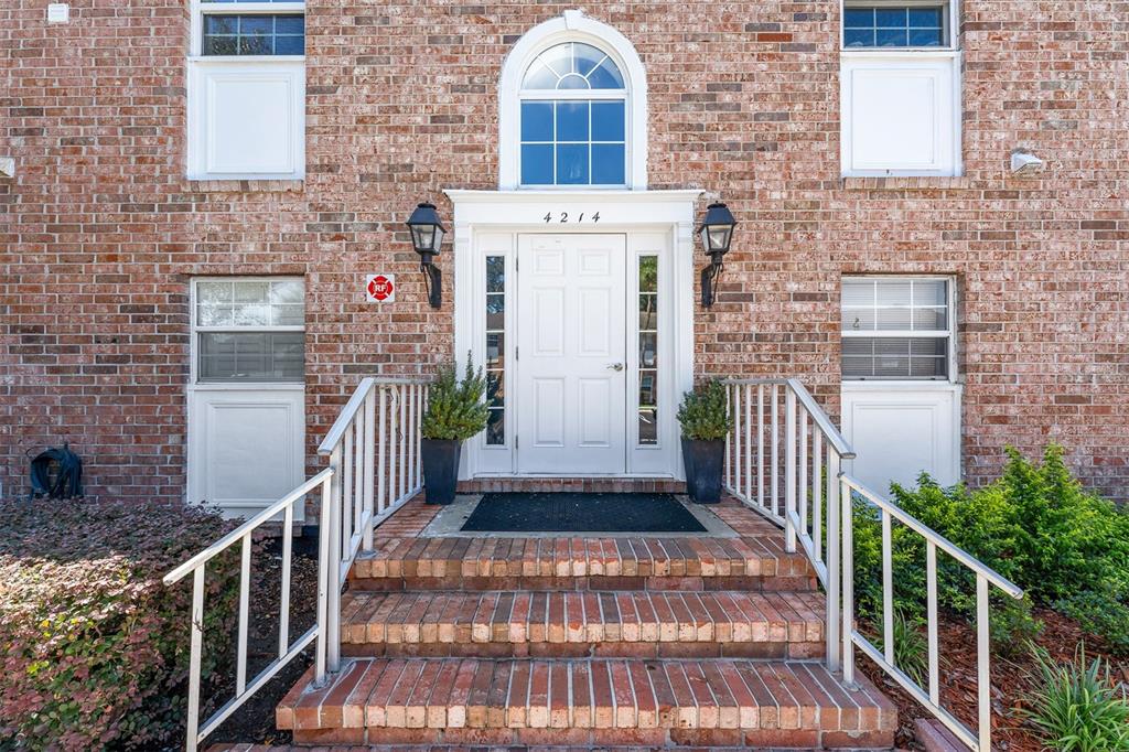 A brick building exterior features a white front door with a transom window and stairs — 4214 LAKE UNDERHILL ROAD UNIT C, ORLANDO, FL
