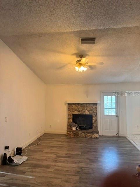 A living room features a stone fireplace, wood-look flooring, and a ceiling fan — 2602 GRAMERCY DRIVE, DELTONA, FL