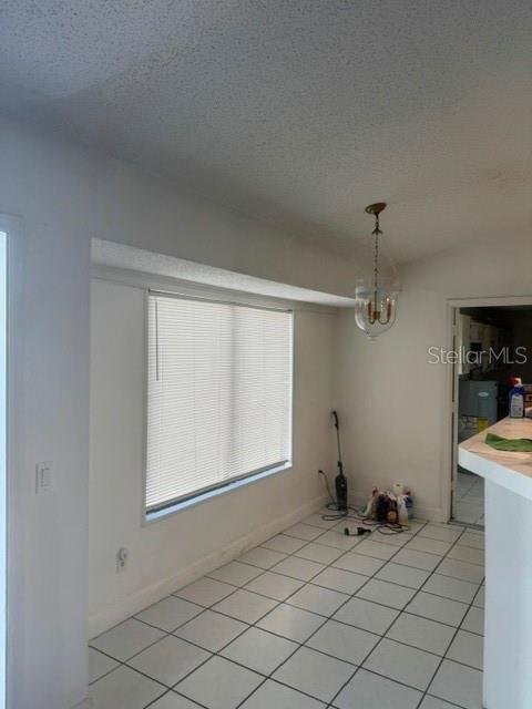 A dining area with white walls, a window with blinds, and white tiled flooring — 2602 GRAMERCY DRIVE, DELTONA, FL
