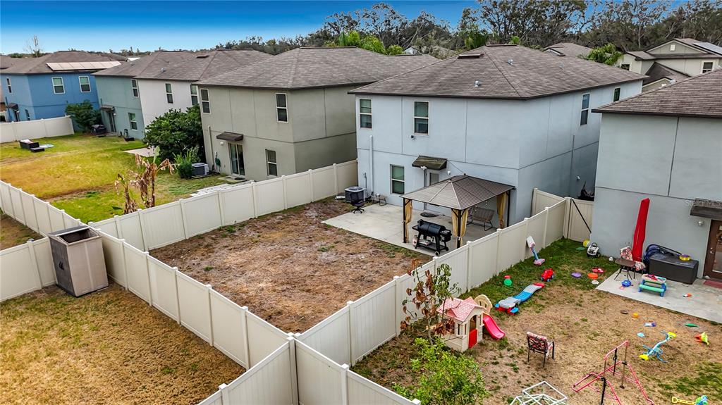 An elevated view of a fenced backyard featuring a patio with a gazebo and toys — 12728 LEMON PEPPER DRIVE, RIVERVIEW, FL
