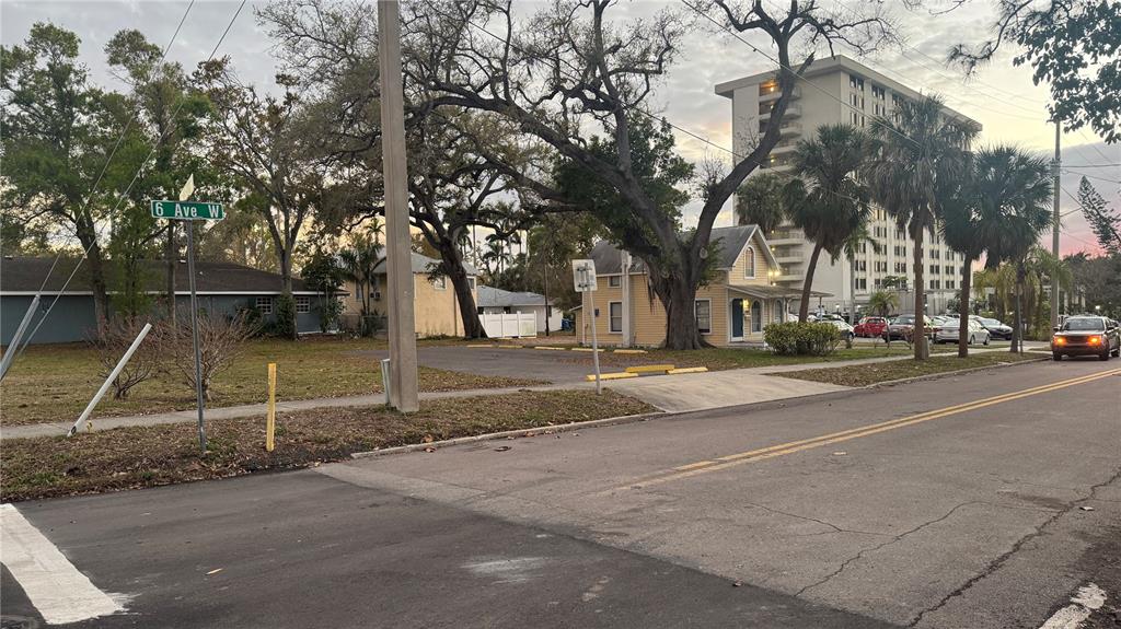 A street view shows a yellow house, a parking lot, and a tall apartment building — 1505 6TH AVENUE W, BRADENTON, FL