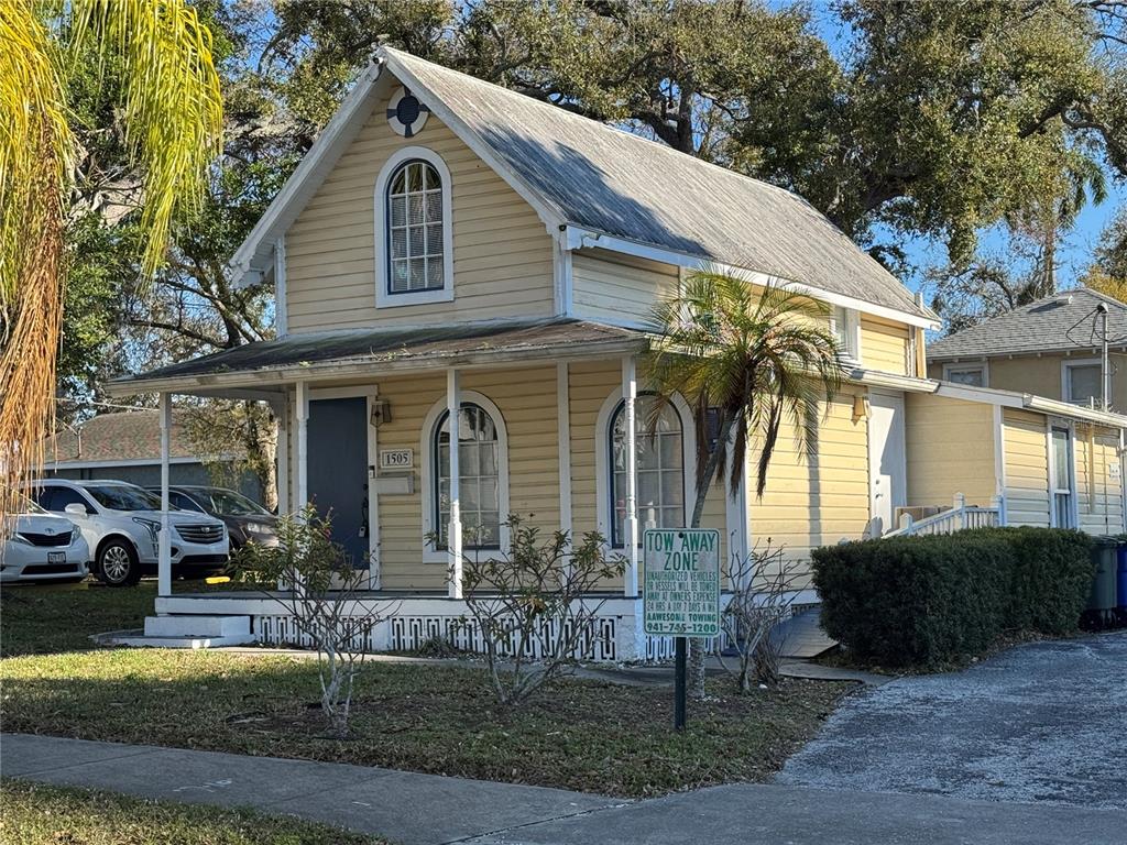 A two-story, yellow wood-sided house with a front porch and arched windows — 1505 6TH AVENUE W, BRADENTON, FL