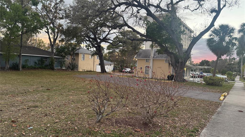A grassy lot with a paved driveway sits in front of two small houses — 1505 6TH AVENUE W, BRADENTON, FL