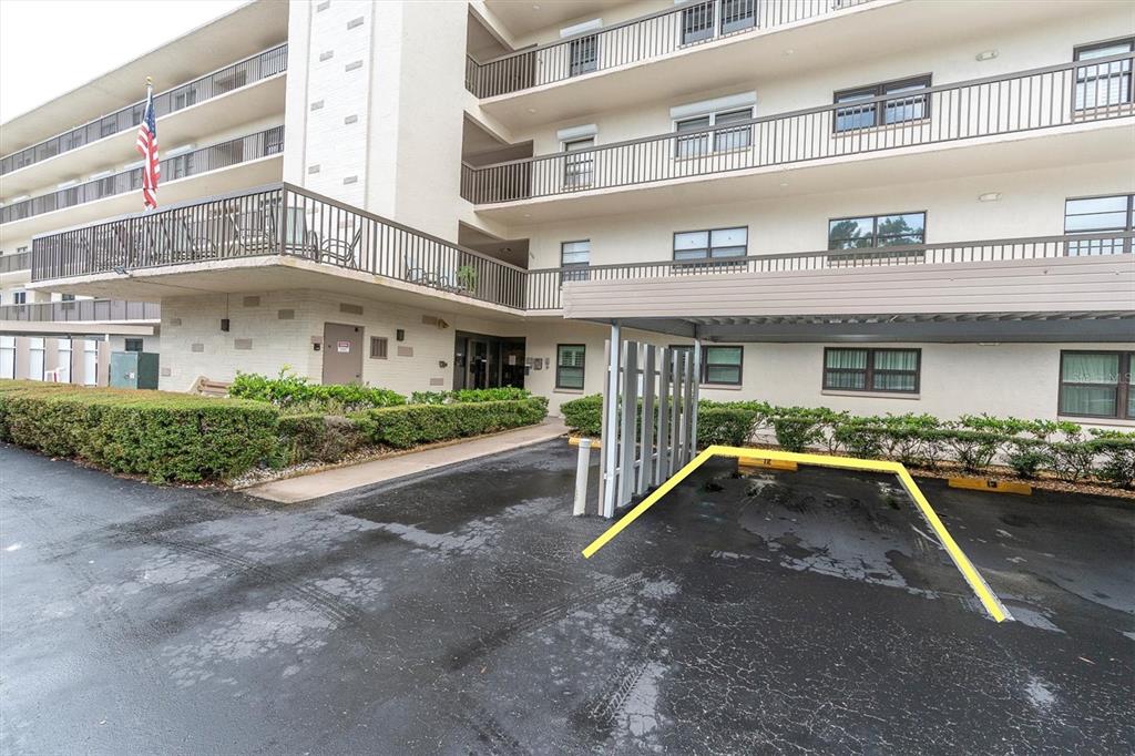 An exterior view of a multi-story apartment building with a covered parking space — 8198 TERRACE GARDEN DRIVE UNIT 511, ST PETERSBURG, FL
