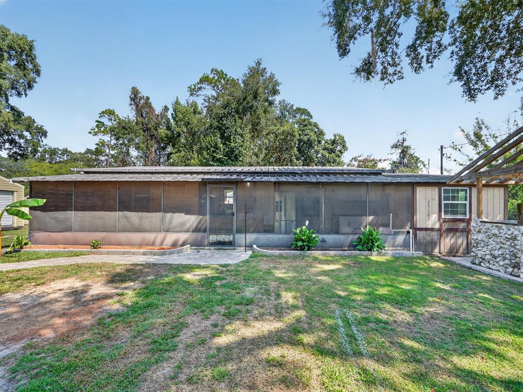 A long, single-story home features a large screened-in porch and a stone-accented exterior wall — 25101 NE 131ST PLACE, FORT MC COY, FL