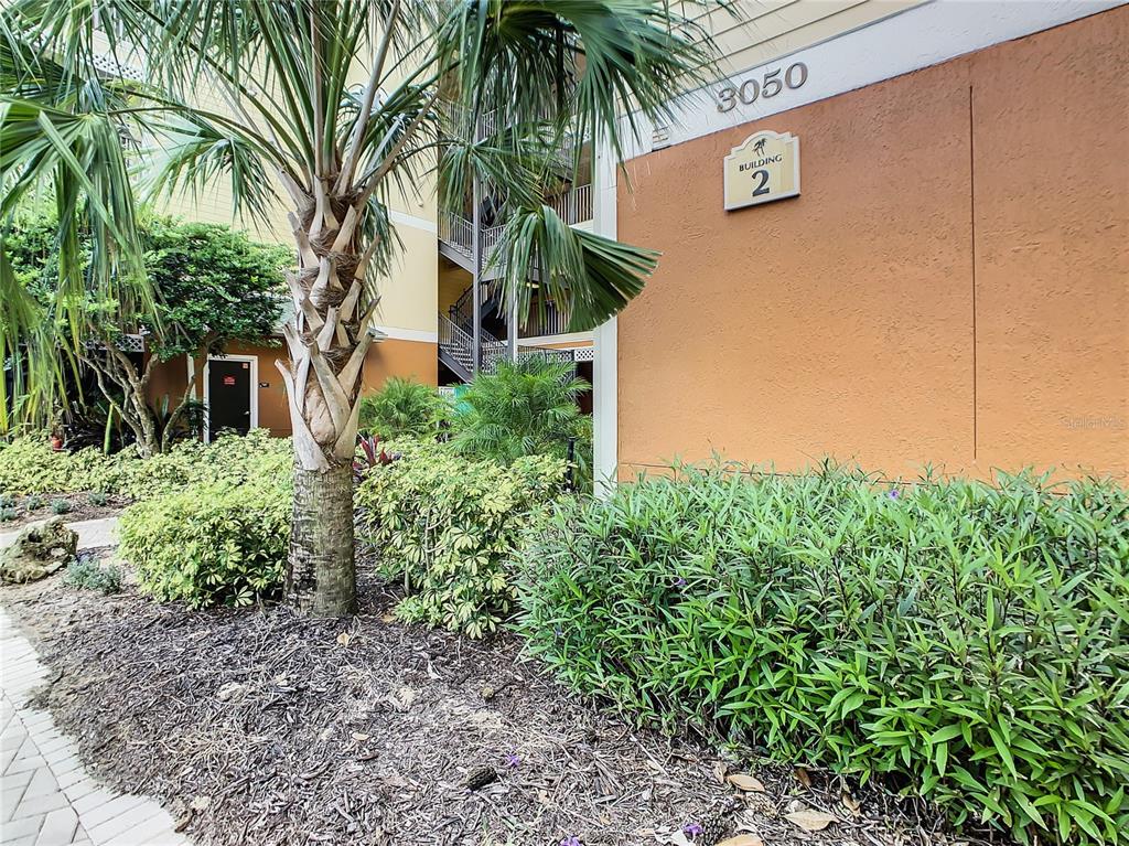 A view of the exterior of a multi-story apartment building labeled building 2 — 3050 PIRATES RETREAT COURT UNIT 207, KISSIMMEE, FL